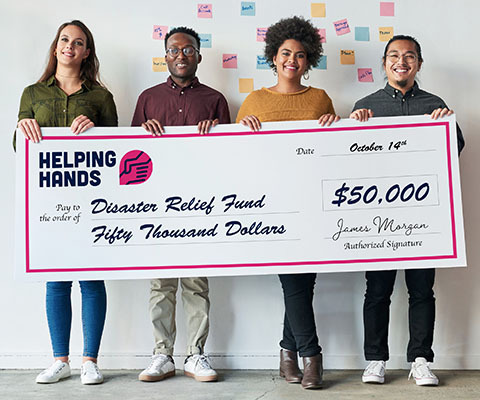 Four people hold up a large check that reads "Helping hands disaster relief fund $50,000."