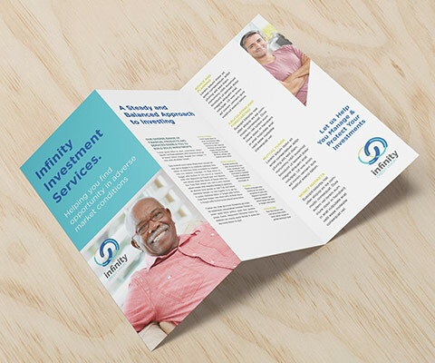 An Infinity Financial Services investment tri-fold brochure laid out on a wood background. The images in the brochure are of an older black man smiling and a younger white male crossing his arms and smiling.