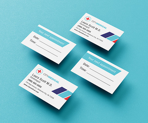 Four City Medical business cards with appoint reminders sitting on a plain baby blue background.