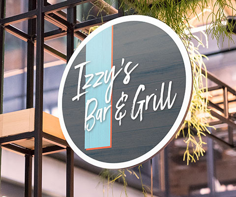 A large circular sign. The sign is gray with a light blue stripe and reads Izzy's Bar & Grill.