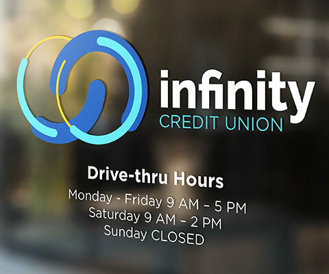 Infinity Credit Union logo showing drive-thru hours on glass