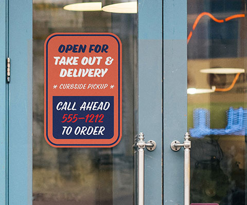 A red sign on a door that reads "open for take out & delivery. Curbside pickup. Call ahead 555-1212 to order"